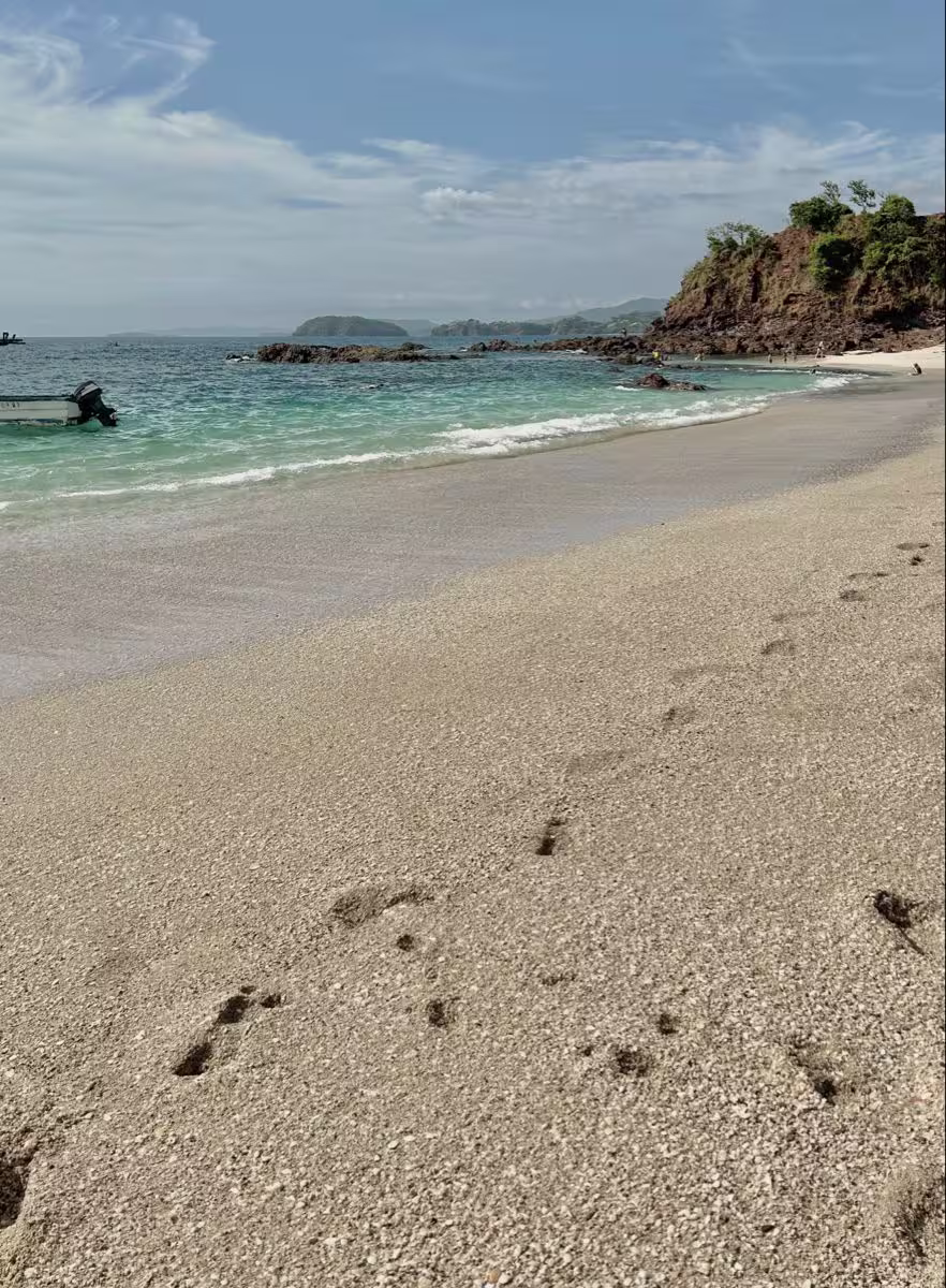 Footprints leading toward a quiet Pacific beach in Costa Rica